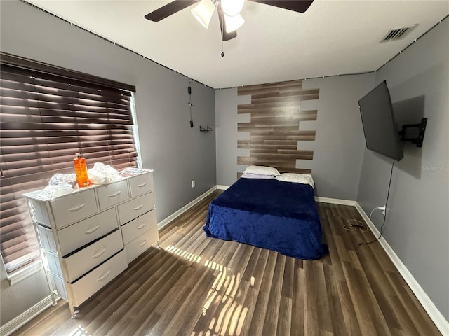 bedroom featuring baseboards, wood finished floors, and a ceiling fan