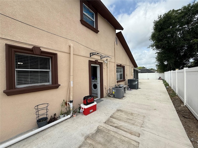 view of patio / terrace featuring central AC unit, washer / dryer, and a fenced backyard