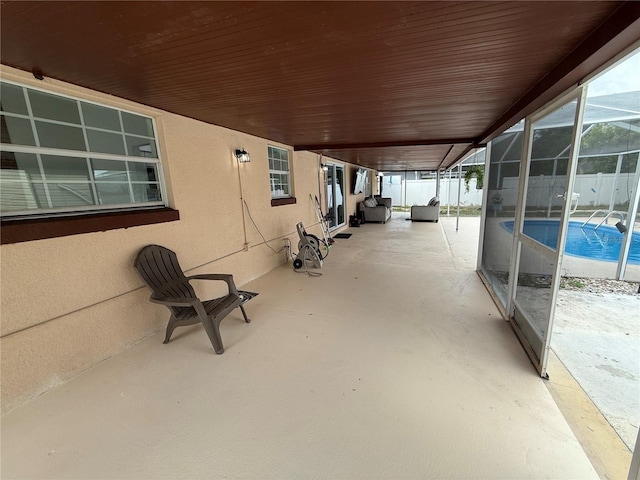 view of patio / terrace featuring glass enclosure and fence