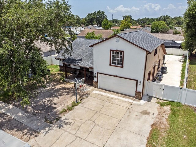 3104 Apricot St, Seffner, FL 33584 - view of front facade with a gate, a garage, concrete driveway, roof with shingles, and stucco siding