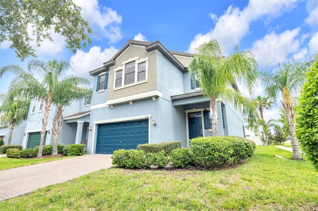 1028 Oliveto Verdi Ct, Brandon, FL 33511 - view of front facade featuring a garage, stucco siding, a front lawn, and decorative driveway