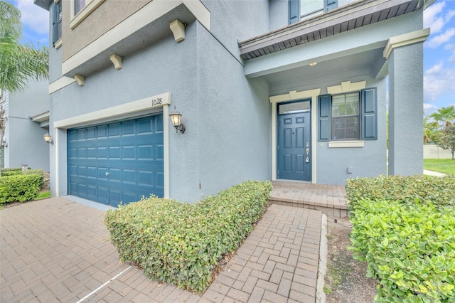 1028 Oliveto Verdi Ct, Brandon, FL 33511 - view of exterior entry featuring stucco siding and an attached garage