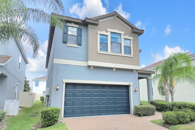 1028 Oliveto Verdi Ct, Brandon, FL 33511 - view of front of home with stucco siding, a garage, decorative driveway, and fence