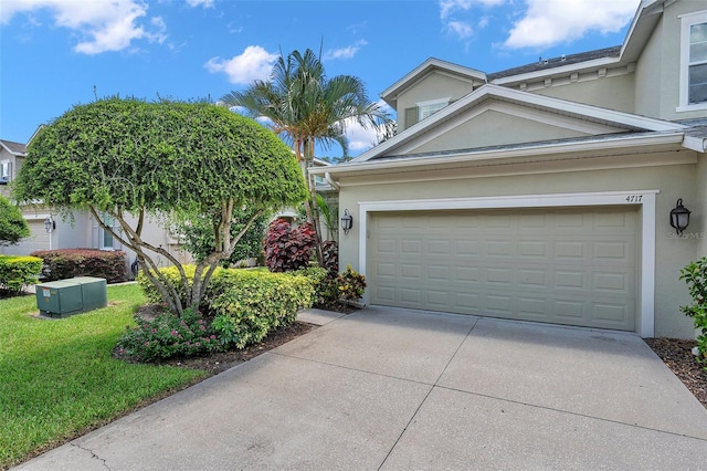 4717 Osprey Ridge Cir, Palm Harbor, FL 34684 - view of front facade featuring stucco siding, driveway, a front yard, and an attached garage