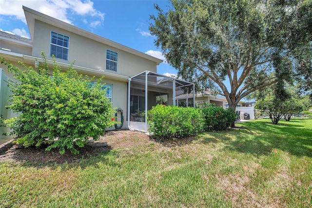 4717 Osprey Ridge Cir, Palm Harbor, FL 34684 - rear view of house with stucco siding, a yard, and glass enclosure