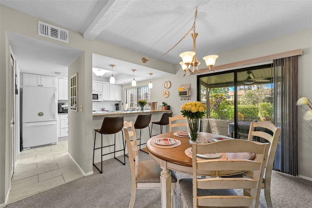 9209 Seminole Blvd Unit 156, Seminole, FL 33772 - dining room with a textured ceiling, a chandelier, light colored carpet, and beamed ceiling