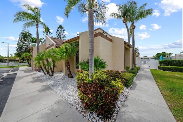 9209 Seminole Blvd Unit 156, Seminole, FL 33772 - view of home's exterior with a gate, stucco siding, and a surveillance system