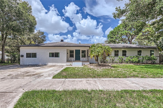 1145 53rd Ave N Unit 1, Saint Petersburg, FL 33703 - ranch-style home featuring brick siding, a porch, a front lawn, and driveway