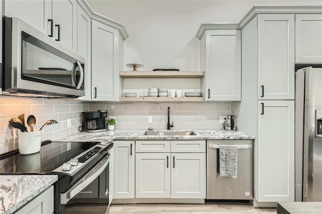 1145 53rd Ave N Unit 1, Saint Petersburg, FL 33703 - kitchen with appliances with stainless steel finishes, a sink, backsplash, open shelves, and light stone counters