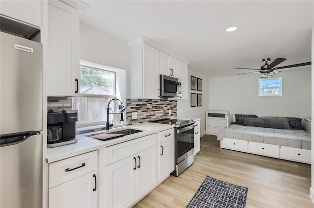 1145 53rd Ave N Unit 1, Saint Petersburg, FL 33703 - kitchen featuring stainless steel appliances, healthy amount of natural light, white cabinetry, tasteful backsplash, and recessed lighting