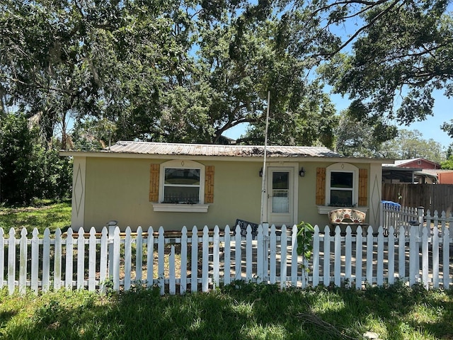 8341 June St, Tampa, FL 33615 - bungalow-style home featuring stucco siding, metal roof, and a fenced front yard