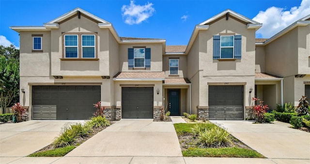 6745 Citrus Creek Ln, Tampa, FL 33625 - townhome / multi-family property featuring an attached garage, stucco siding, stone siding, and driveway