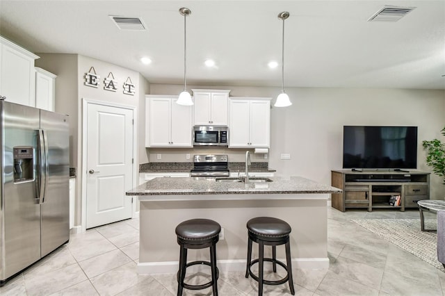 6745 Citrus Creek Ln, Tampa, FL 33625 - kitchen with appliances with stainless steel finishes, a sink, open floor plan, stone countertops, and a center island with sink