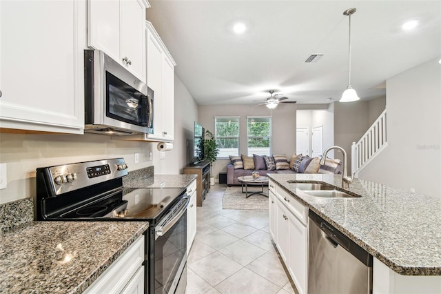 6745 Citrus Creek Ln, Tampa, FL 33625 - kitchen featuring stainless steel appliances, a sink, ceiling fan, open floor plan, and white cabinetry