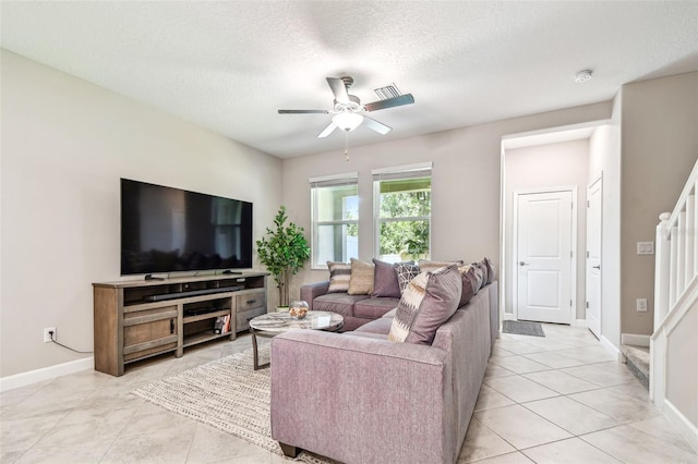 6745 Citrus Creek Ln, Tampa, FL 33625 - living area featuring stairs, a ceiling fan, baseboards, light tile patterned floors, and a textured ceiling