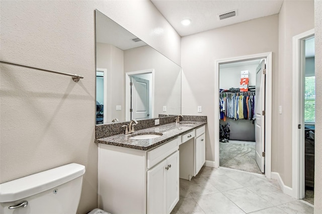 6745 Citrus Creek Ln, Tampa, FL 33625 - bathroom featuring toilet, double vanity, tile patterned floors, a walk in closet, and baseboards