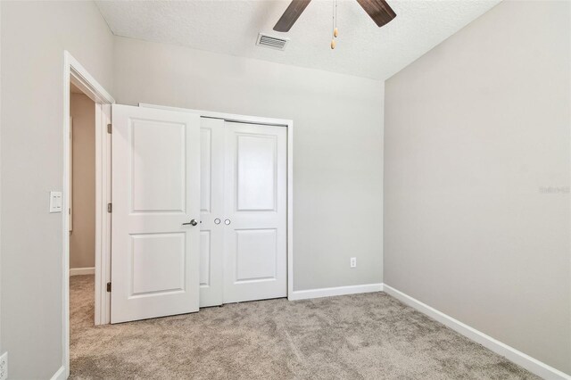 6745 Citrus Creek Ln, Tampa, FL 33625 - unfurnished bedroom with light carpet, baseboards, a closet, a textured ceiling, and a ceiling fan