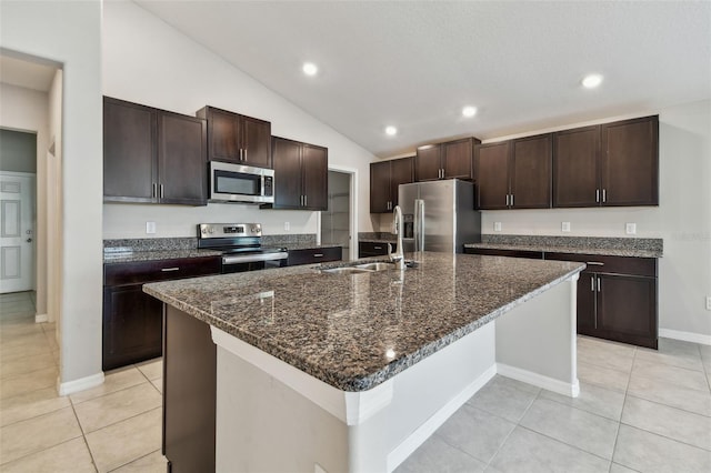 10822 Crushed Grape Dr, Riverview, FL 33578 - kitchen with stainless steel appliances, a sink, light tile patterned floors, dark brown cabinetry, and vaulted ceiling