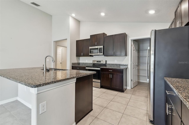 10822 Crushed Grape Dr, Riverview, FL 33578 - kitchen with stainless steel appliances, a sink, light tile patterned floors, dark brown cabinetry, and high vaulted ceiling