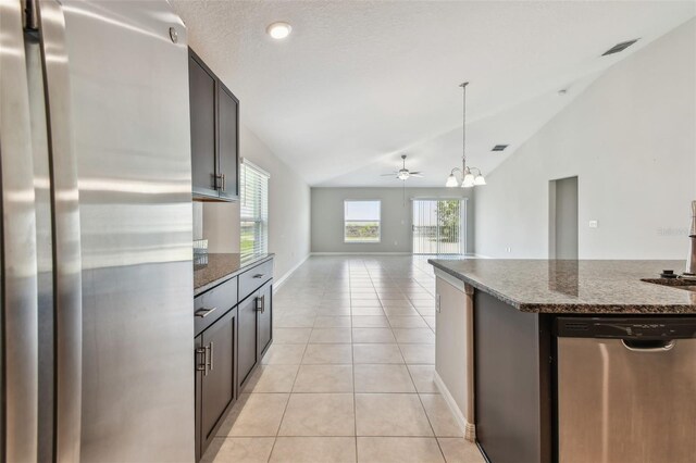 10822 Crushed Grape Dr, Riverview, FL 33578 - kitchen featuring appliances with stainless steel finishes, lofted ceiling, a chandelier, light tile patterned floors, and dark stone countertops