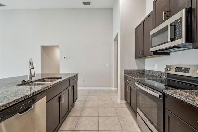 10822 Crushed Grape Dr, Riverview, FL 33578 - kitchen with stainless steel appliances, a sink, dark stone counters, and dark brown cabinetry