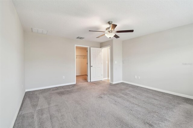 10822 Crushed Grape Dr, Riverview, FL 33578 - unfurnished bedroom featuring baseboards, a walk in closet, carpet flooring, ceiling fan, and a closet