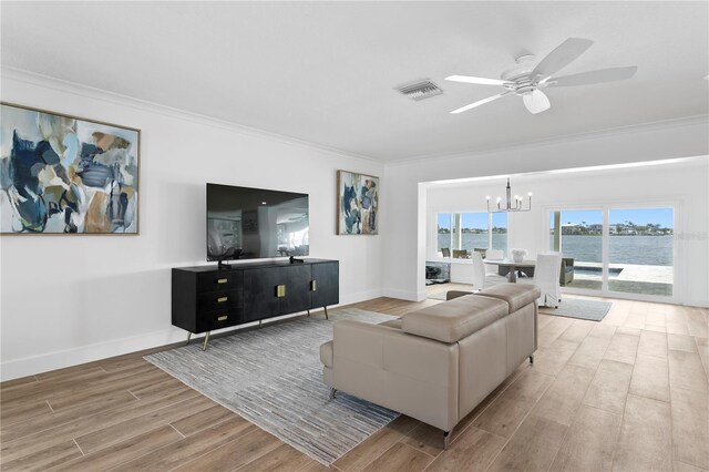 7060 S Shore Dr S, South Pasadena, FL 33707 - living area with crown molding, a chandelier, wood finished floors, a ceiling fan, and baseboards