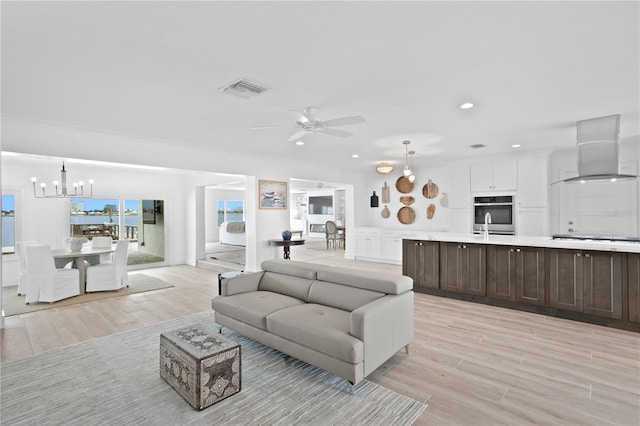 7060 S Shore Dr S, South Pasadena, FL 33707 - living room featuring a chandelier, light wood finished floors, a ceiling fan, and recessed lighting
