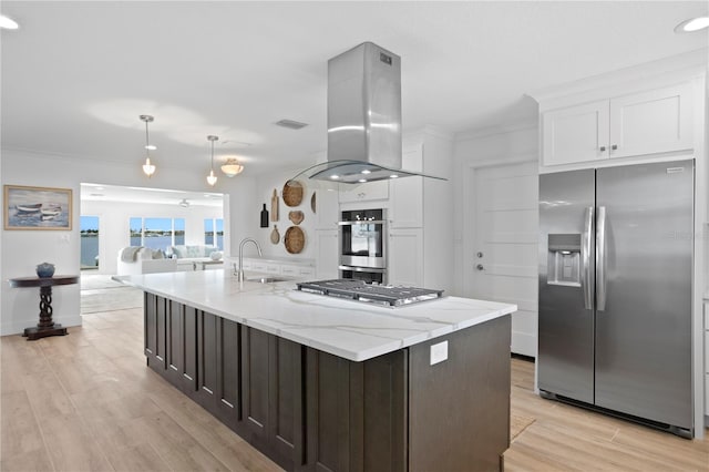 7060 S Shore Dr S, South Pasadena, FL 33707 - kitchen featuring appliances with stainless steel finishes, island exhaust hood, white cabinets, ornamental molding, and light wood finished floors