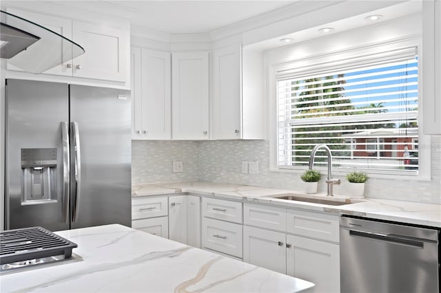 7060 S Shore Dr S, South Pasadena, FL 33707 - kitchen featuring stainless steel appliances, a sink, white cabinets, decorative backsplash, and light stone countertops