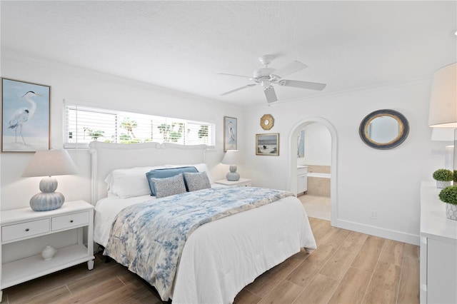 7060 S Shore Dr S, South Pasadena, FL 33707 - bedroom featuring ornamental molding, light wood-style floors, arched walkways, baseboards, and ensuite bath