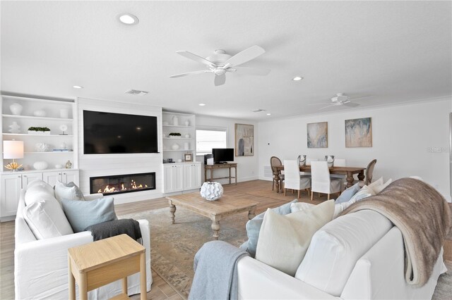 7060 S Shore Dr S, South Pasadena, FL 33707 - living area with a ceiling fan, recessed lighting, light wood-style floors, a large fireplace, and baseboards