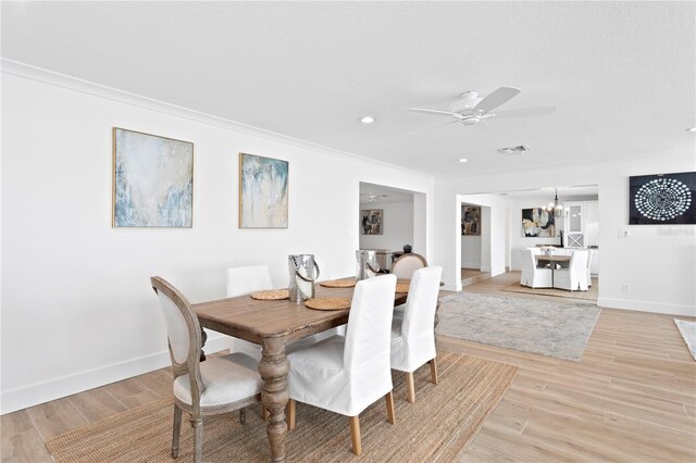 7060 S Shore Dr S, South Pasadena, FL 33707 - dining room with a chandelier, light wood-style flooring, ceiling fan, baseboards, and ornamental molding