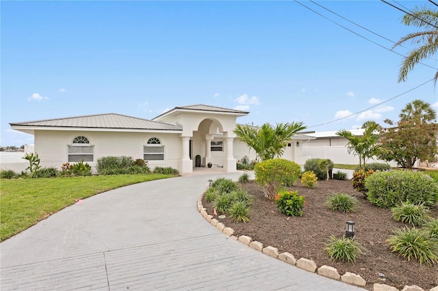 7060 S Shore Dr S, South Pasadena, FL 33707 - mediterranean / spanish house featuring stucco siding, curved driveway, and a front yard