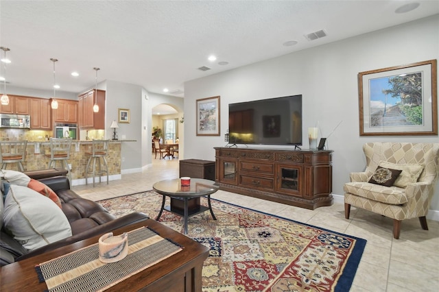 1116 Hillandale Reserve Dr, Tampa, FL 33613 - living room with arched walkways, light tile patterned flooring, recessed lighting, and baseboards