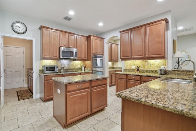 1116 Hillandale Reserve Dr, Tampa, FL 33613 - kitchen with a sink, appliances with stainless steel finishes, light stone countertops, tasteful backsplash, and light tile patterned floors