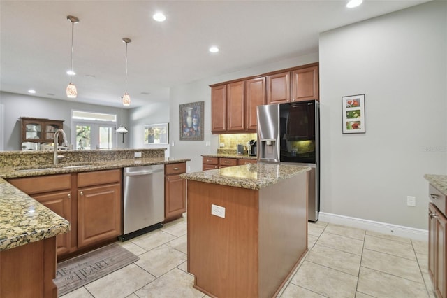 1116 Hillandale Reserve Dr, Tampa, FL 33613 - kitchen featuring appliances with stainless steel finishes, a sink, tasteful backsplash, a center island, and brown cabinets