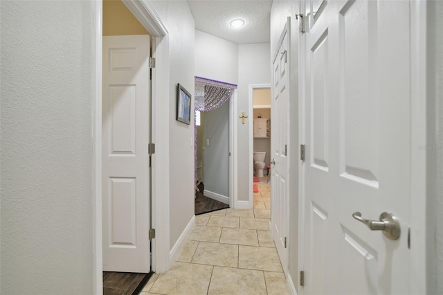 1116 Hillandale Reserve Dr, Tampa, FL 33613 - corridor featuring a textured ceiling, light tile patterned flooring, and baseboards