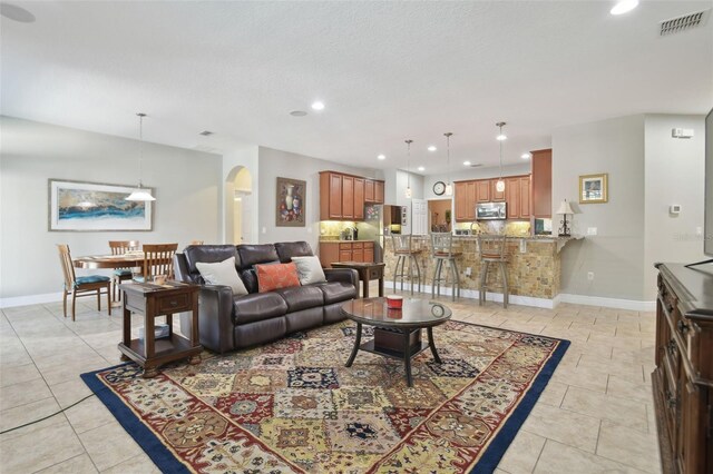 1116 Hillandale Reserve Dr, Tampa, FL 33613 - living room featuring recessed lighting, arched walkways, baseboards, and light tile patterned floors