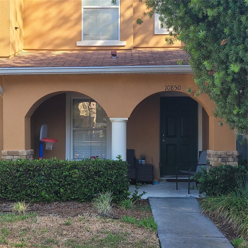 10850 Lake Saint Charles Blvd, Riverview, FL 33578 - entrance to property featuring stucco siding, covered porch, and a shingled roof