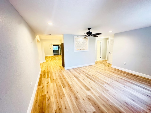 unfurnished living room featuring light wood-style flooring, a ceiling fan, baseboards, and recessed lighting