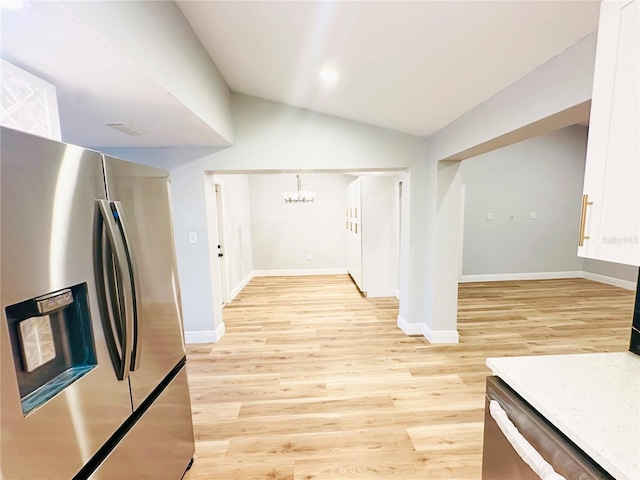 corridor with a chandelier, light wood finished floors, baseboards, and lofted ceiling
