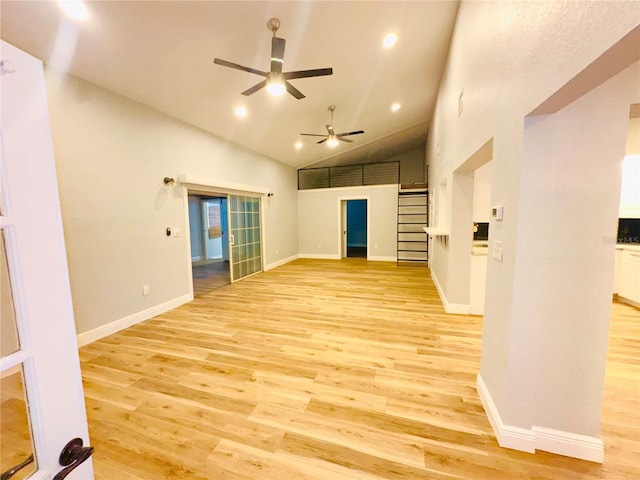 unfurnished living room featuring light wood-style floors, ceiling fan, baseboards, and high vaulted ceiling