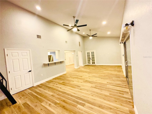 unfurnished living room featuring ceiling fan, high vaulted ceiling, recessed lighting, wood finished floors, and french doors