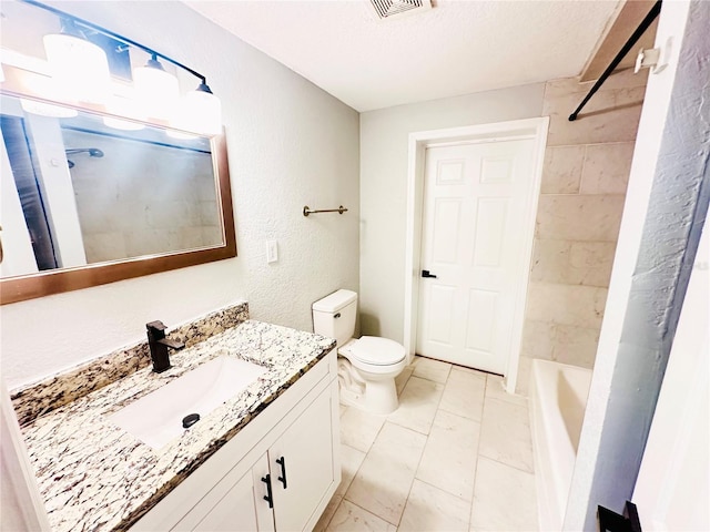 bathroom featuring marble finish floors, toilet, vanity, a textured ceiling, and a textured wall