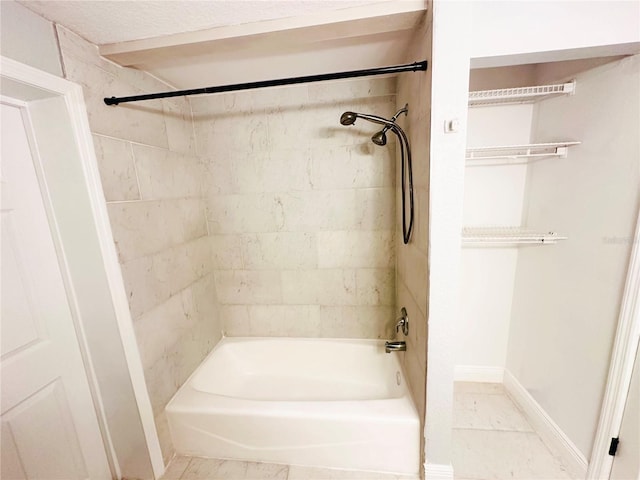 bathroom featuring bathtub / shower combination and baseboards