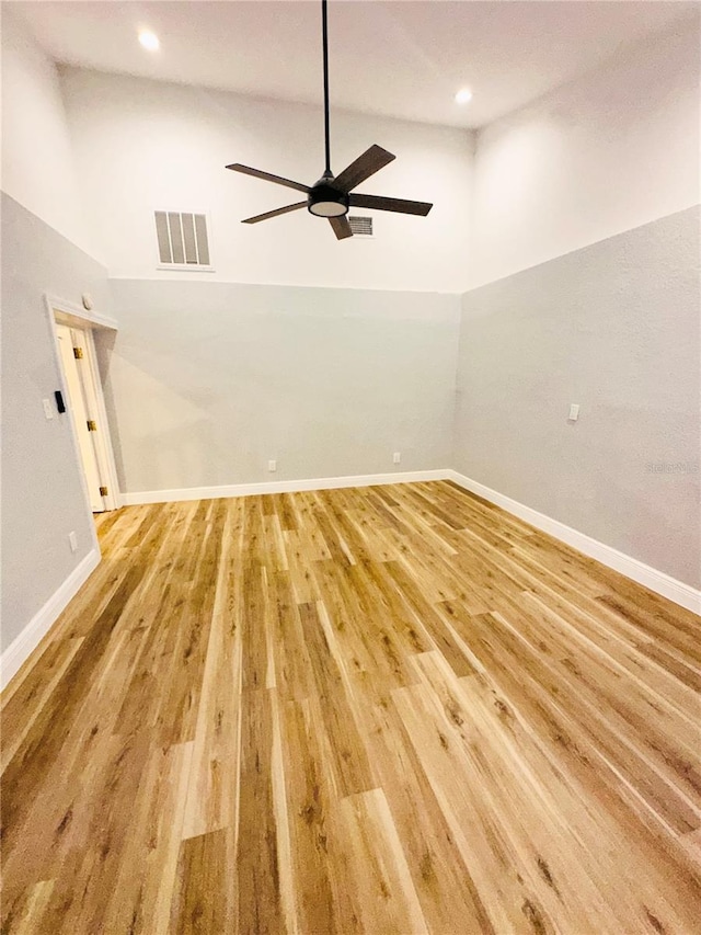 empty room with lofted ceiling, ceiling fan, light wood-style floors, baseboards, and recessed lighting