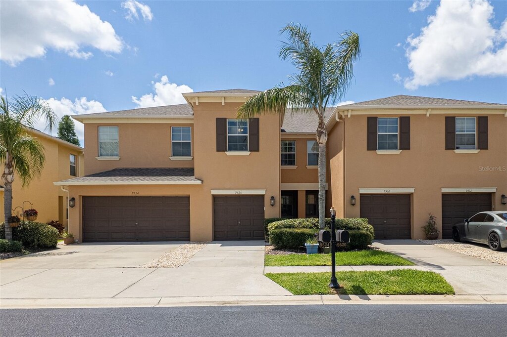 9520 Trumpet Vine Loop, Trinity, FL 34655 - multi unit property featuring an attached garage, stucco siding, and driveway
