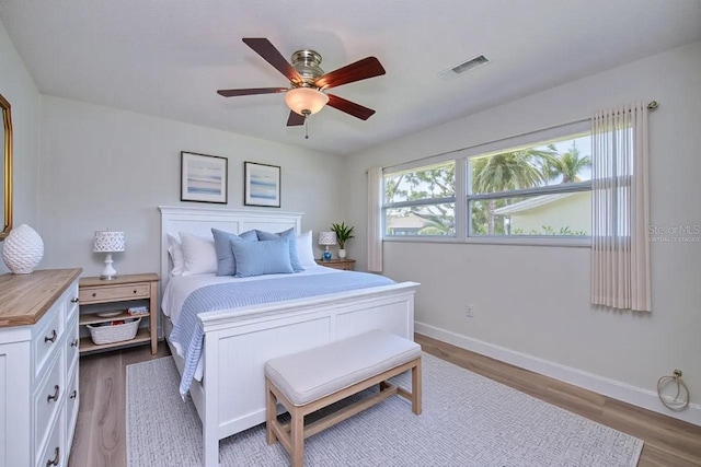 bedroom with wood finished floors, baseboards, and ceiling fan