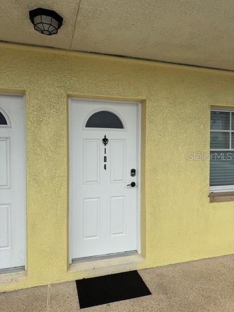 entrance to property with stucco siding
